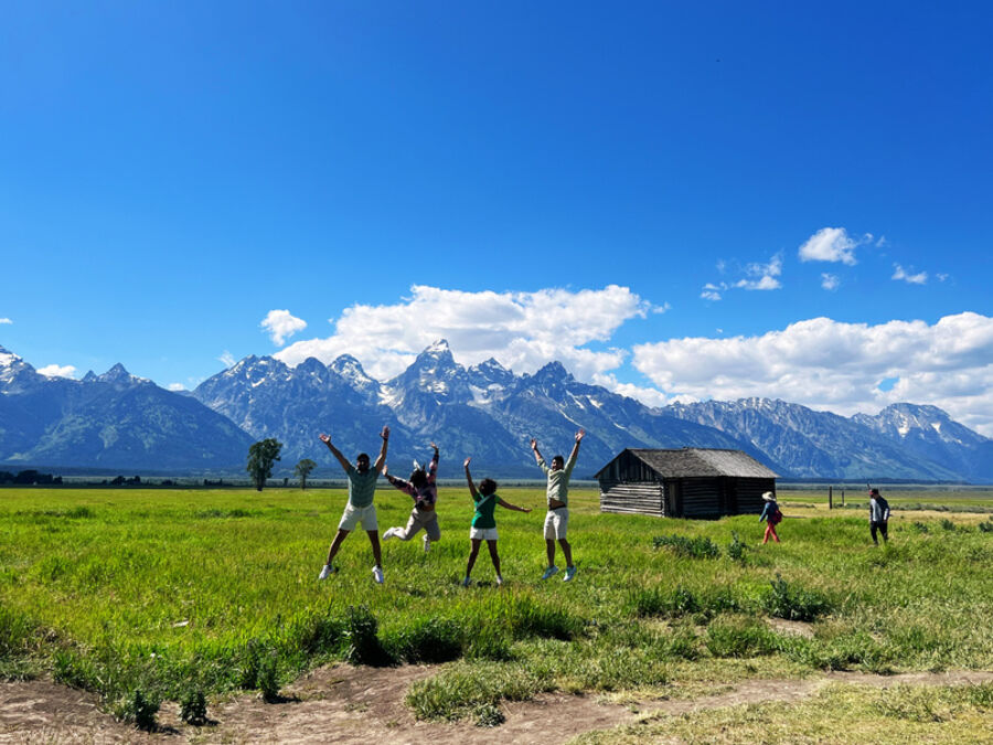 Jumping in a field below the Tetons